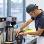 Der Barista an der Kaffemaschine Der Barista an der Kaffemaschine